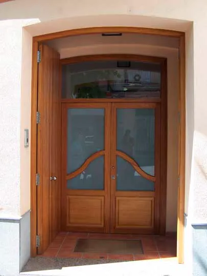 Entrada con puerta de madera rehabilitada por Construcciones Mogar