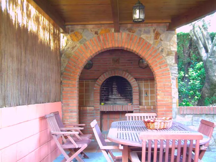 Patio con porche y chimenea rehabilitado por Construcciones Mogar